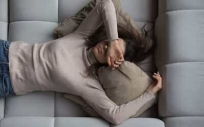 Peaceful girl lying on back on comfortable couch at home Peaceful pretty 20s girl lying on back on comfortable couch at home, covering eyes with hand, sleeping at daytime, feeling tired, enjoying relaxation, leisure, break, weekend. Top view