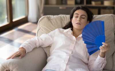 Stressed millennial Hispanic woman feeling overheated at home. Stressed millennial Hispanic woman feeling overheated at home.